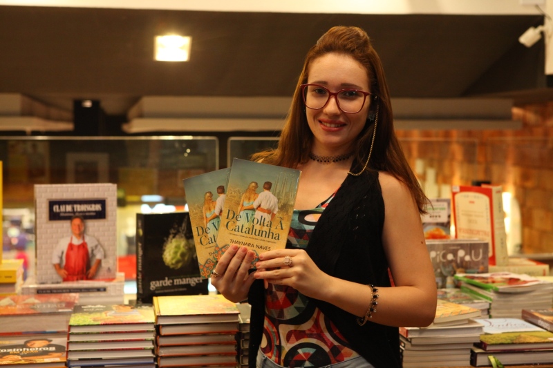 Thaynara Naves com seu livro em livraria da Capital 