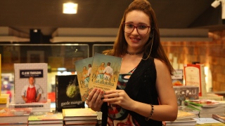 Thaynara Naves com seu livro em livraria da Capital 
