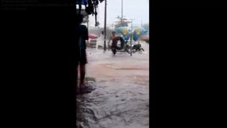 Homem anda em boia na água da chuva