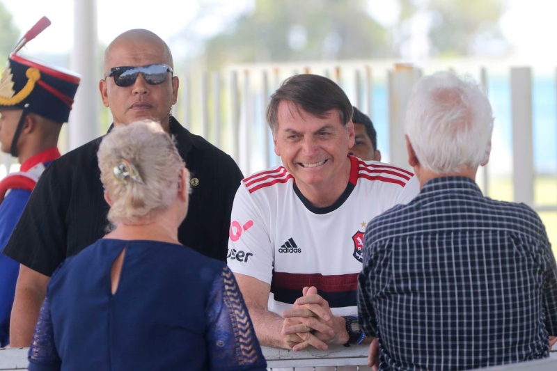 O presidente Jair Bolsonaro cumprimenta turistas no Alvorada