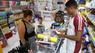  Janaína Sousa escolhendo os itens para o filho com a ajuda do vendedor Marcos Jesus 