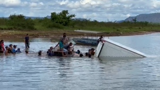Moradores com barco pegam as mercadorias do caminhão afundado