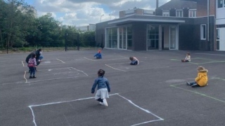 Crianças brincam separadas por limitações de giz desenhadas no chão