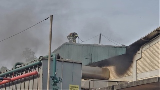 Bombeiros no telhado da fábrica